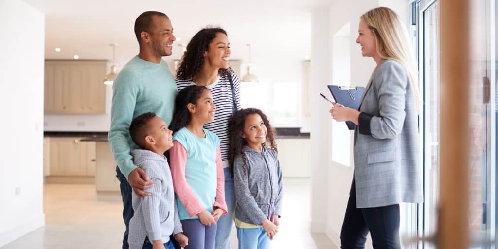 Female Realtor Showing Family Interested in Buying Around House